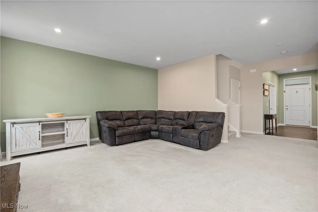 Carpeted living room featuring recessed lighting and stairway