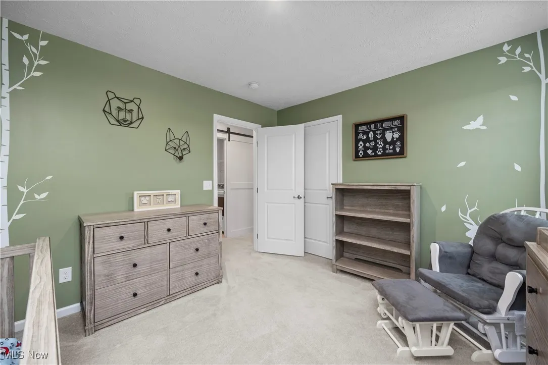 Bedroom with a  light carpet and a textured ceiling