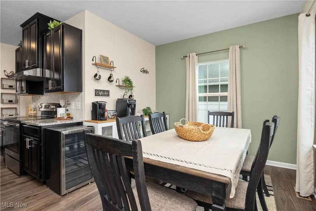 Dining space with dark wood-style flooring and wine cooler