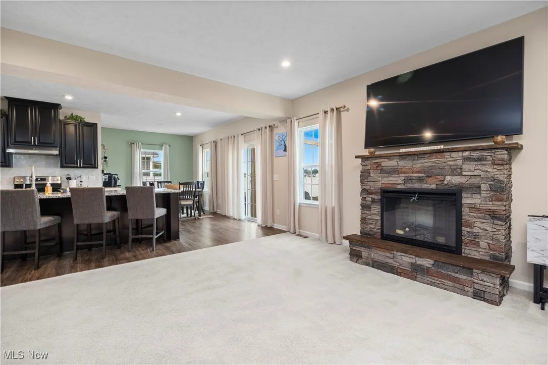 Living room with dark colored carpet, healthy amount of natural light, a fireplace, and recessed lighting