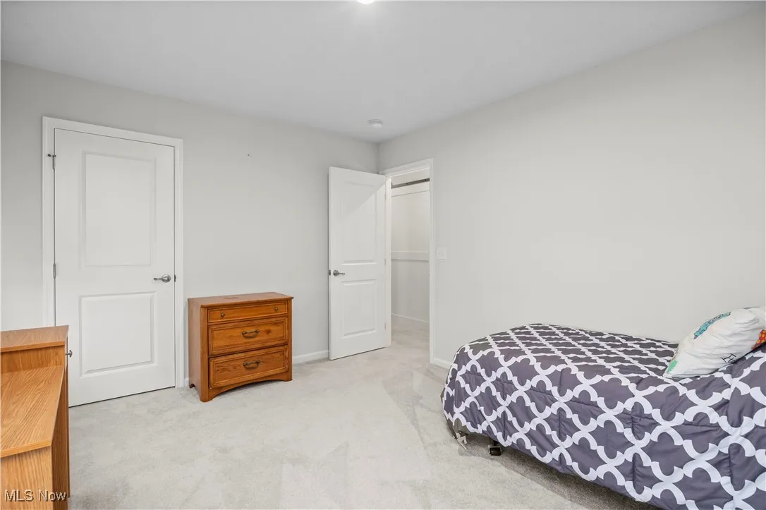 Bedroom with light carpet and baseboards