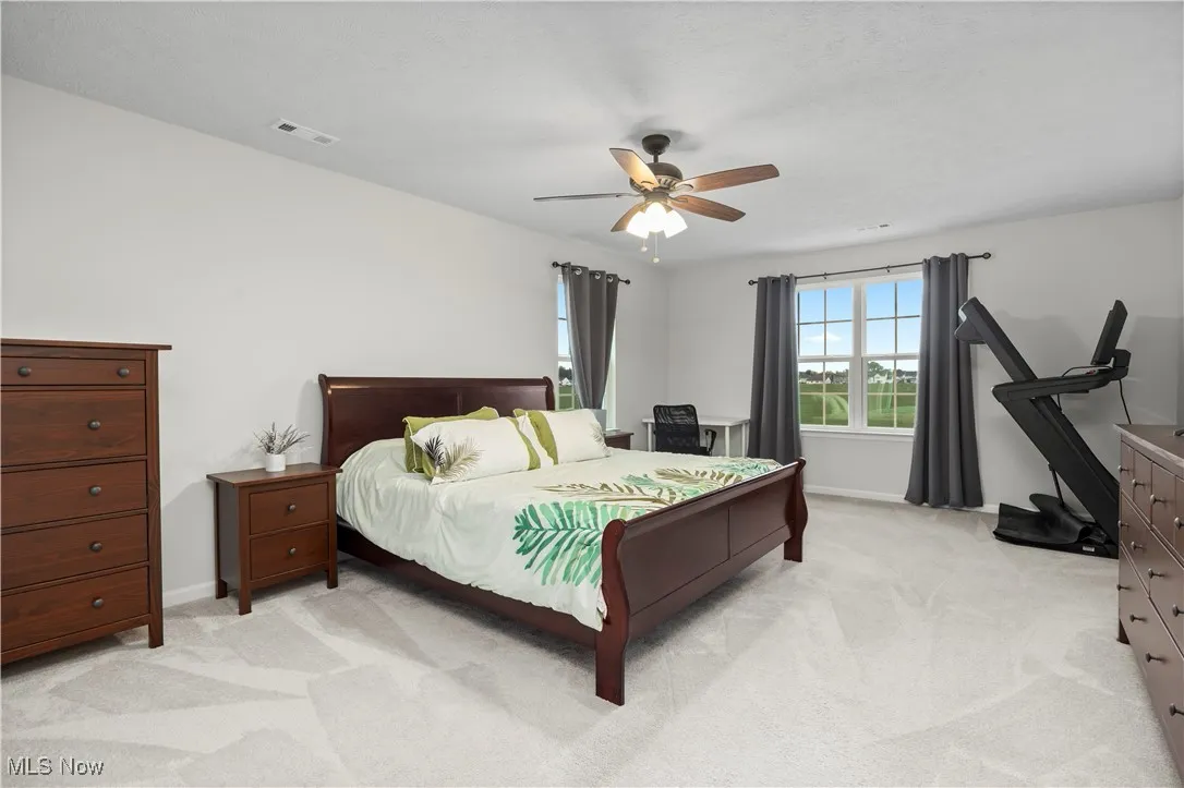 Bedroom with light carpet and ceiling fan