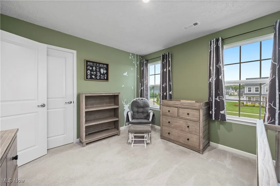 Bedroom featuring light colored carpet and a textured ceiling