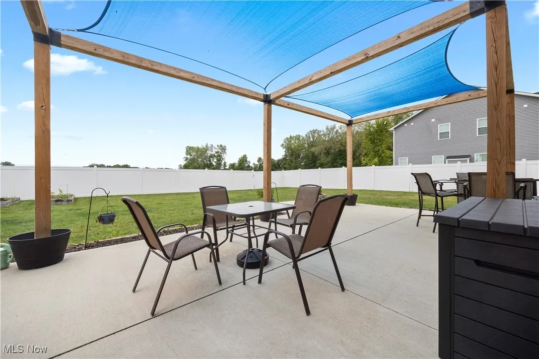 Fenced backyard with outdoor dining space and a patio