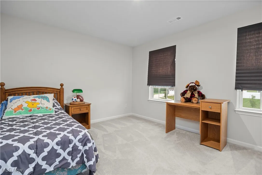 Bedroom featuring light carpet and baseboards