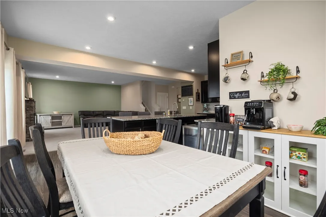 Dining space with dark wood-type flooring and recessed lighting
