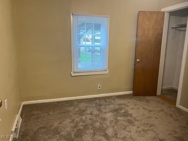 Unfurnished bedroom featuring carpet and a closet