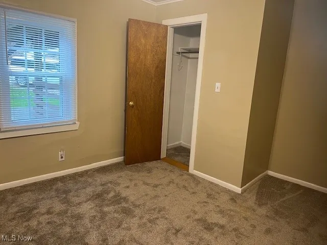 Unfurnished bedroom featuring carpet flooring and ornamental molding