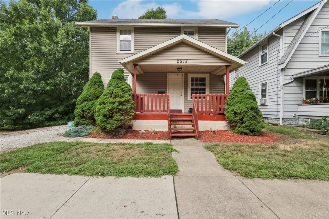 View of front of property with covered porch, gravel driveway and front yard