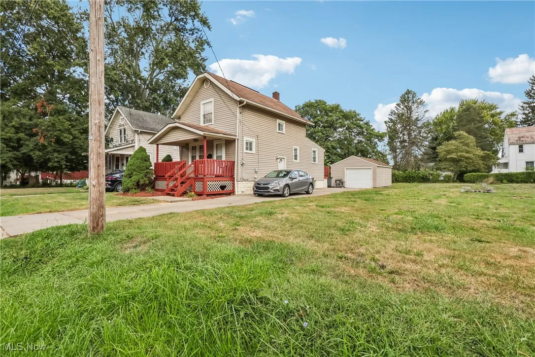 View of side of house featuring a covered porch, concrete driveway and 1.5 car detached garage.
