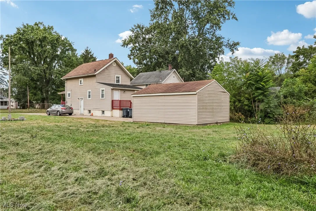 View of back yard featuring wooded area and a detached 2 car garage