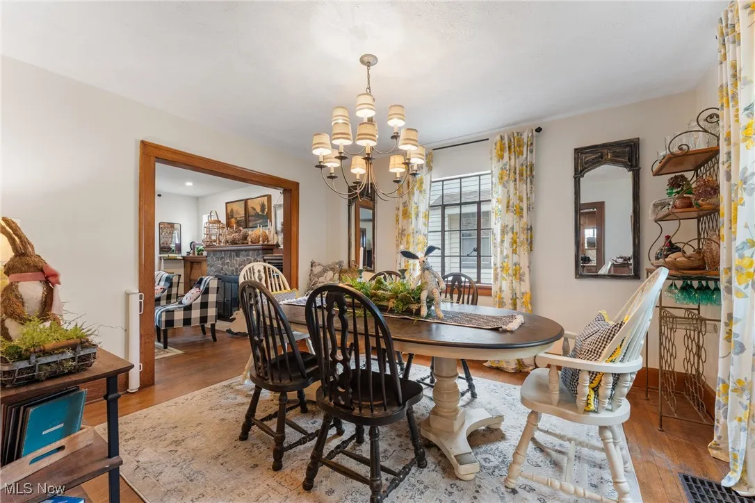 Dining area featuring a chandelier, wood finished floors, and a fireplace