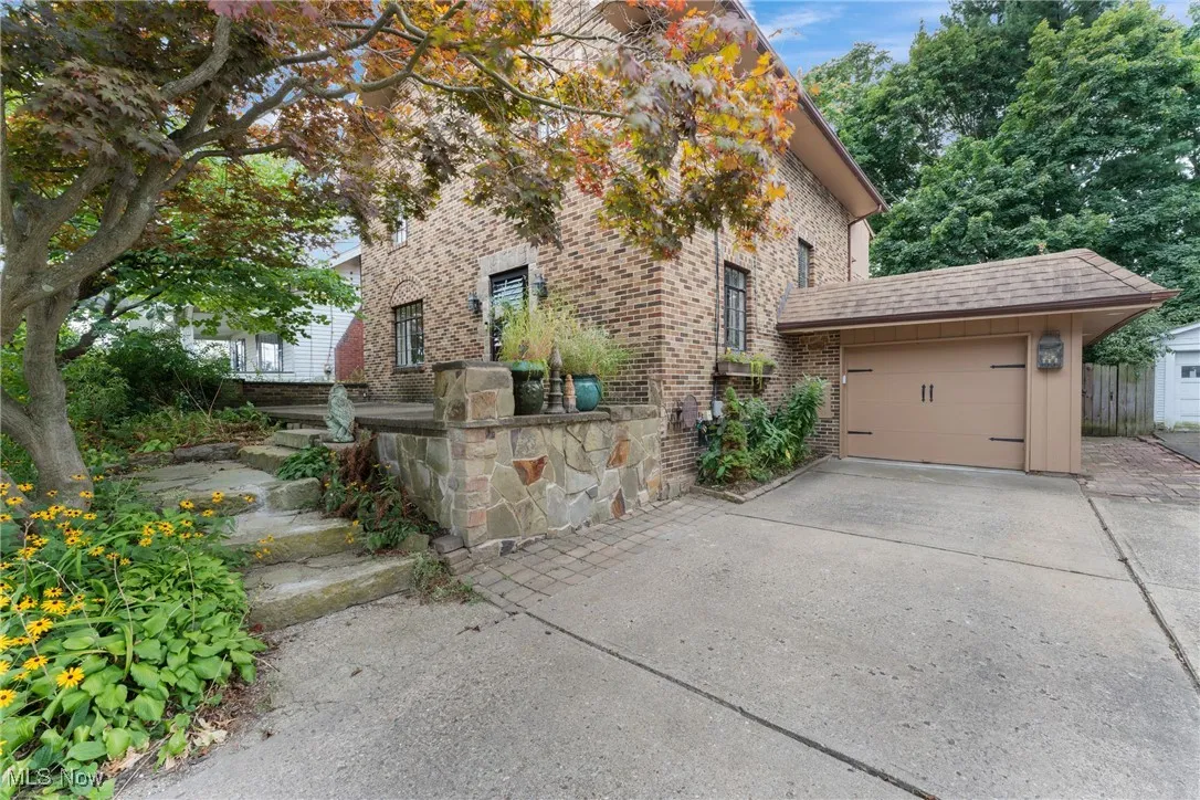 View of home's exterior featuring brick siding, concrete driveway, roof with shingles, and an attached garage