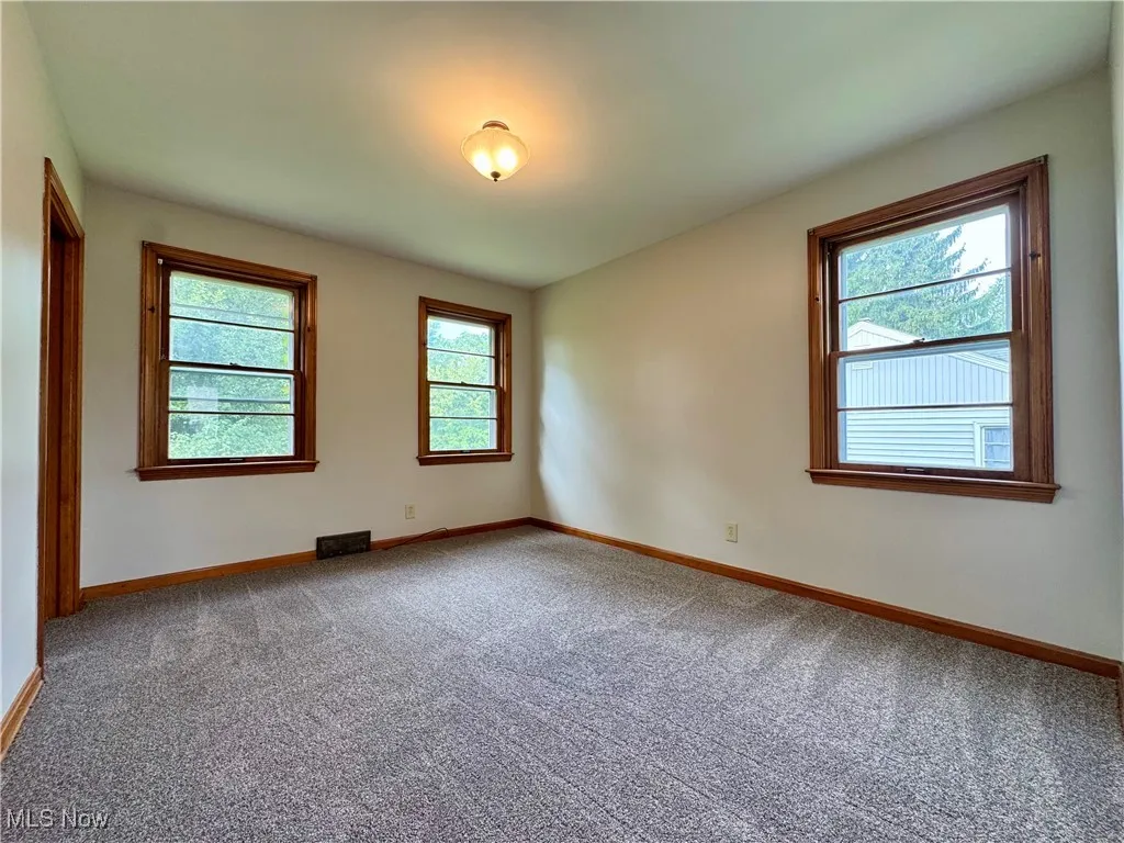 Carpeted empty room with baseboards