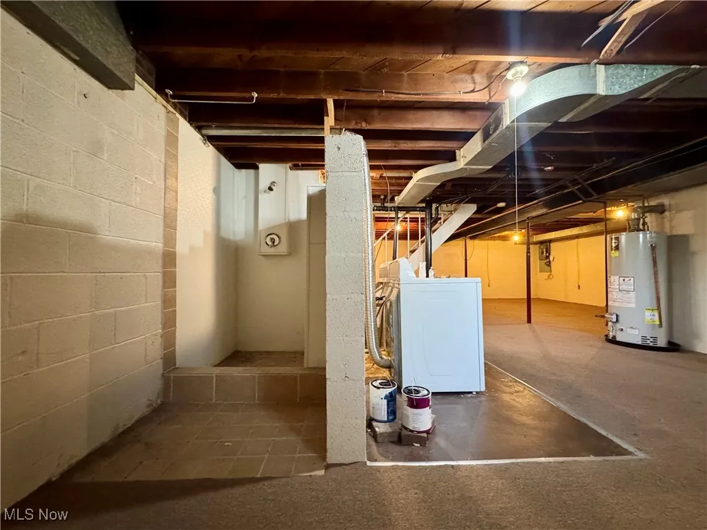 Unfinished basement with washer / clothes dryer and water heater