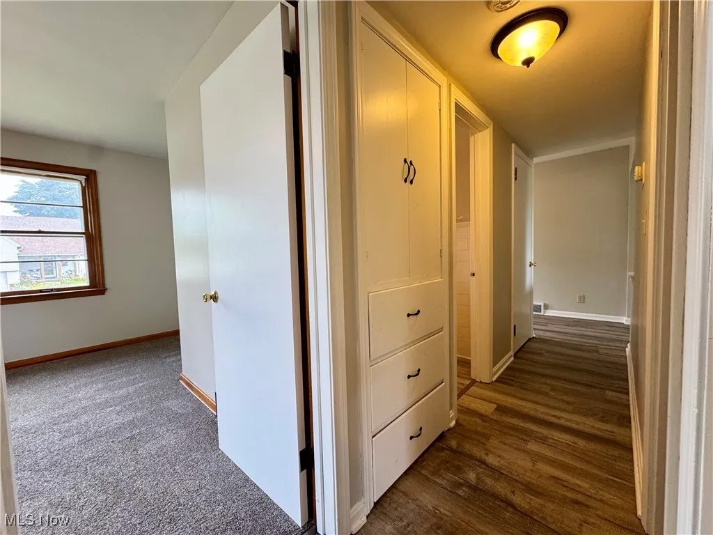 Hallway featuring baseboards and dark wood-style floors