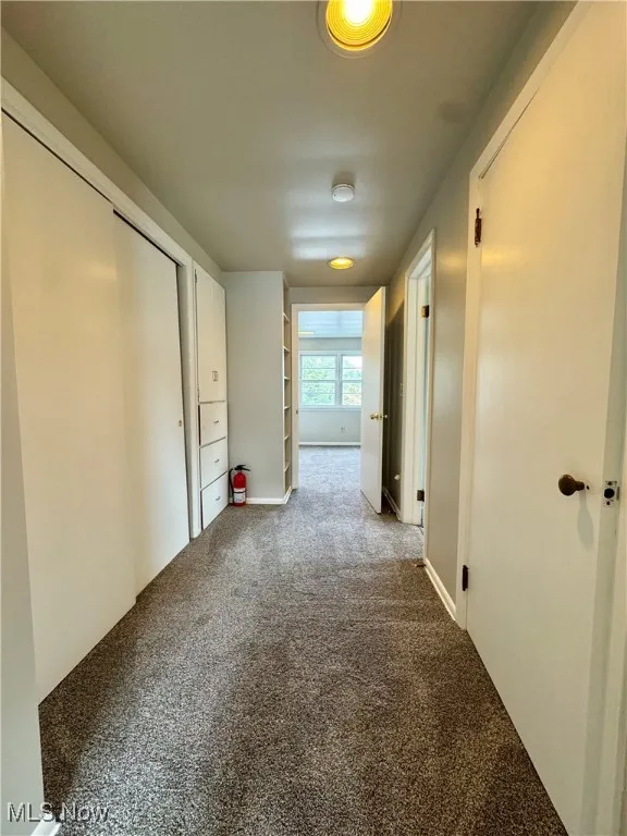 Corridor featuring carpet flooring