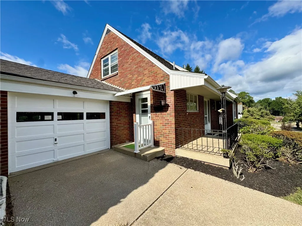 View of front of property featuring brick siding, asphalt driveway, and an attached garage