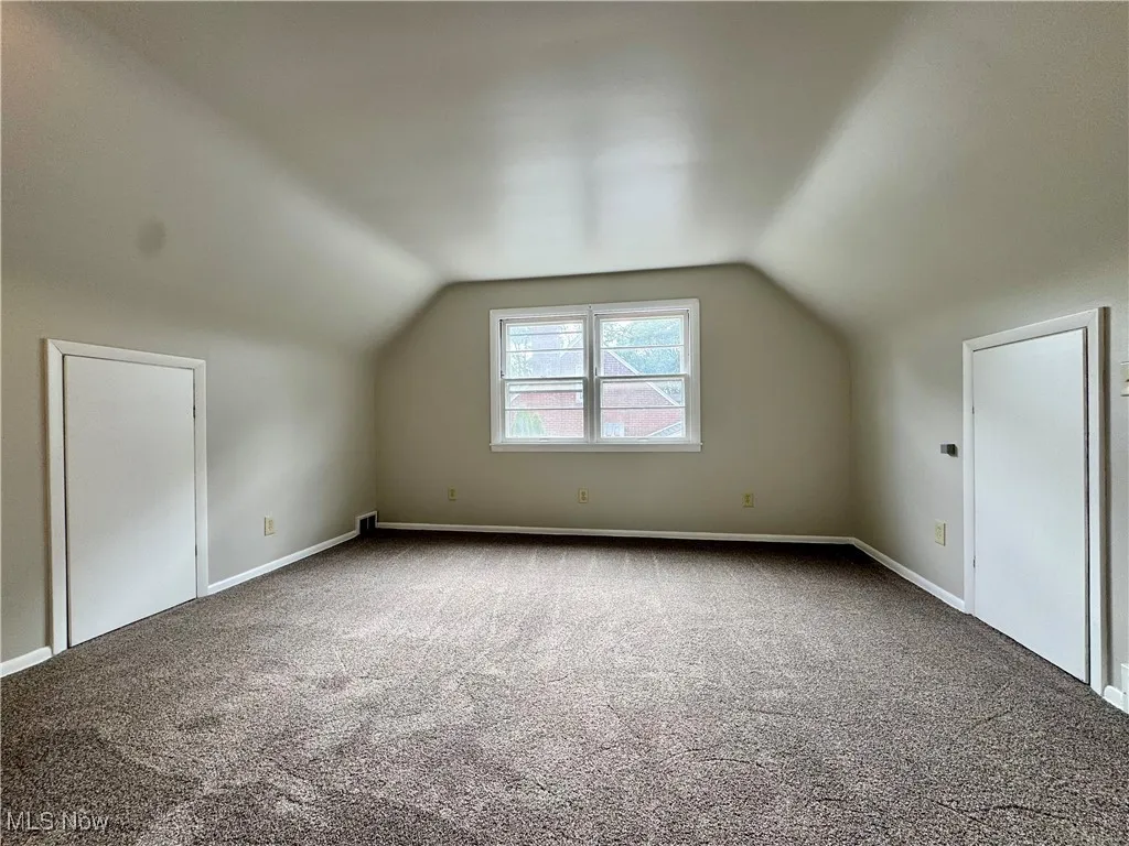 Bonus room featuring lofted ceiling and carpet