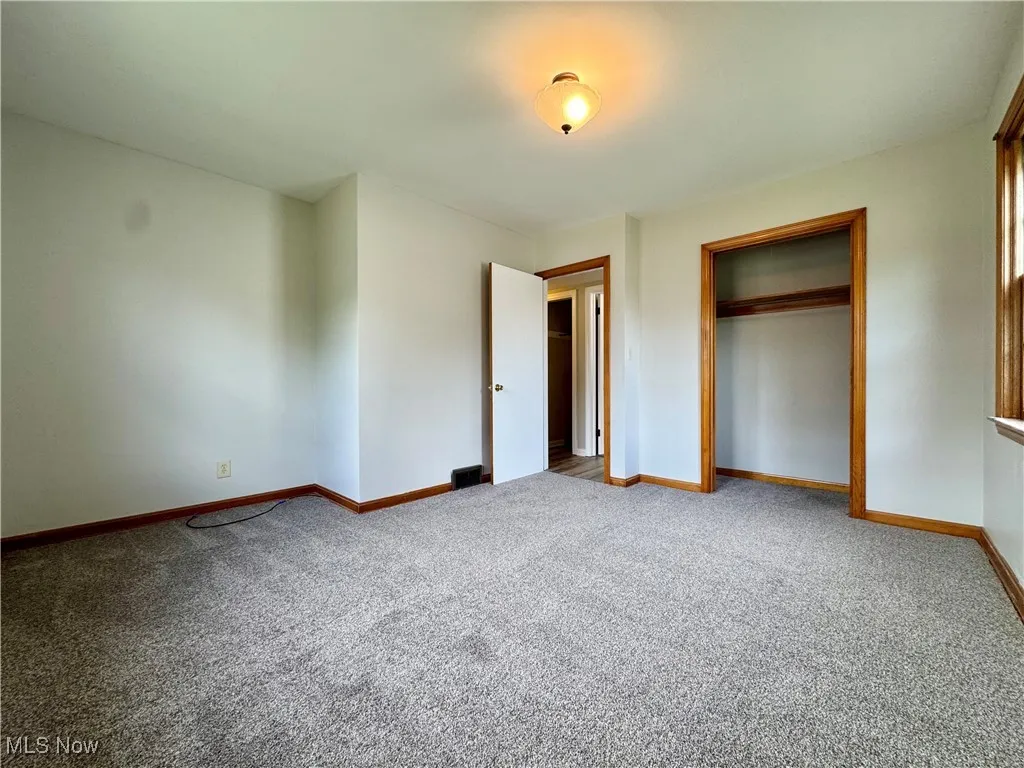 Unfurnished bedroom featuring carpet and a closet