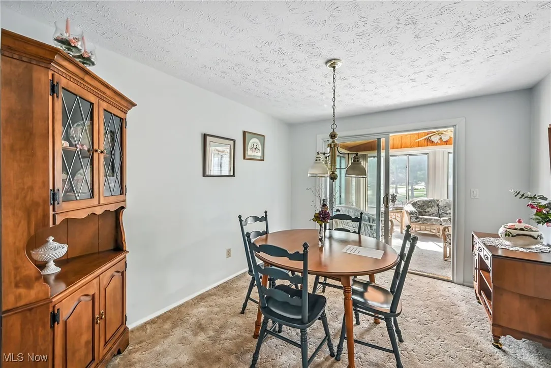 Dining area featuring a textured ceiling and light colored carpet
