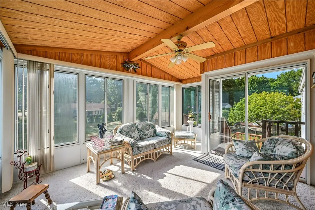 Sunroom featuring a ceiling fan and an outdoor living space
