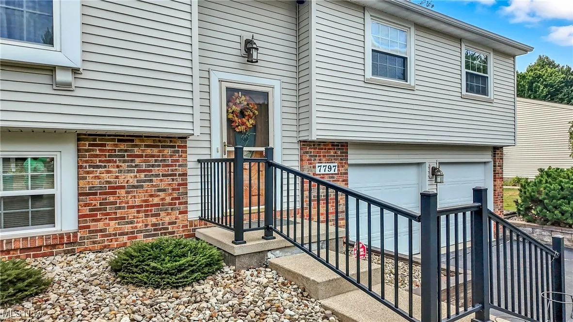 Entrance to property featuring brick siding and a garage
