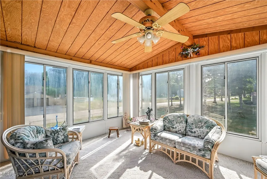 Sunroom featuring carpet flooring and wooden ceiling