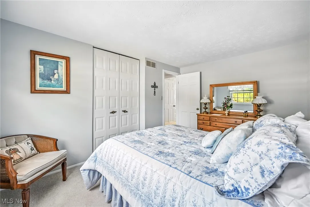 Bedroom featuring carpet floors, a closet, and a textured ceiling