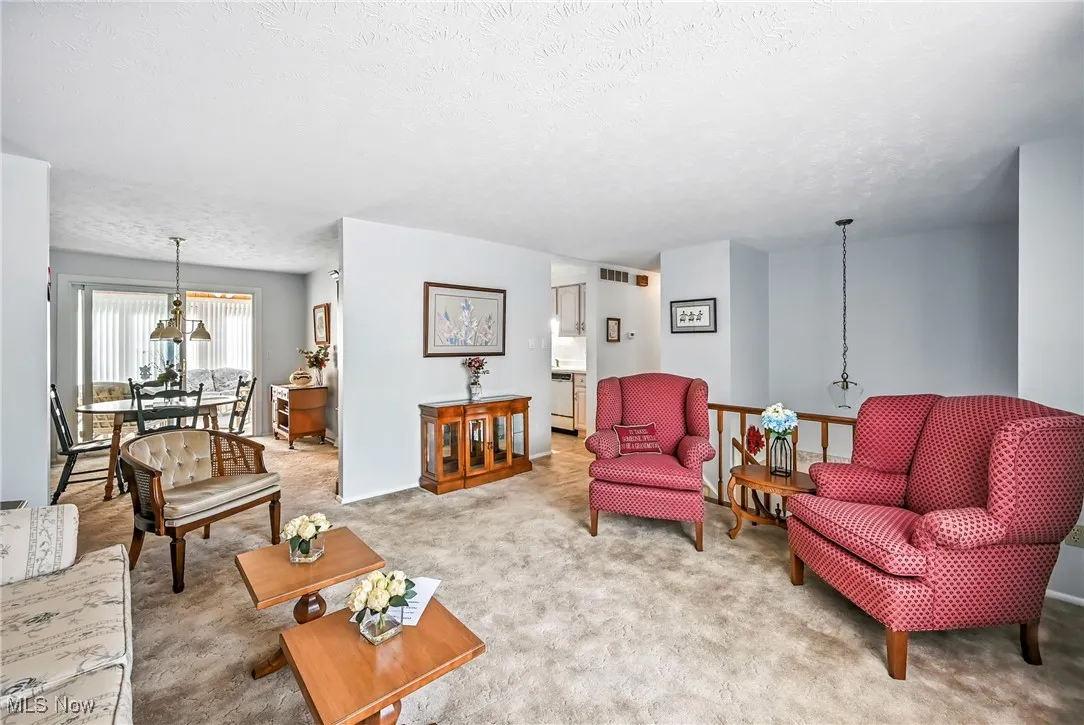 Living area with carpet flooring and a textured ceiling