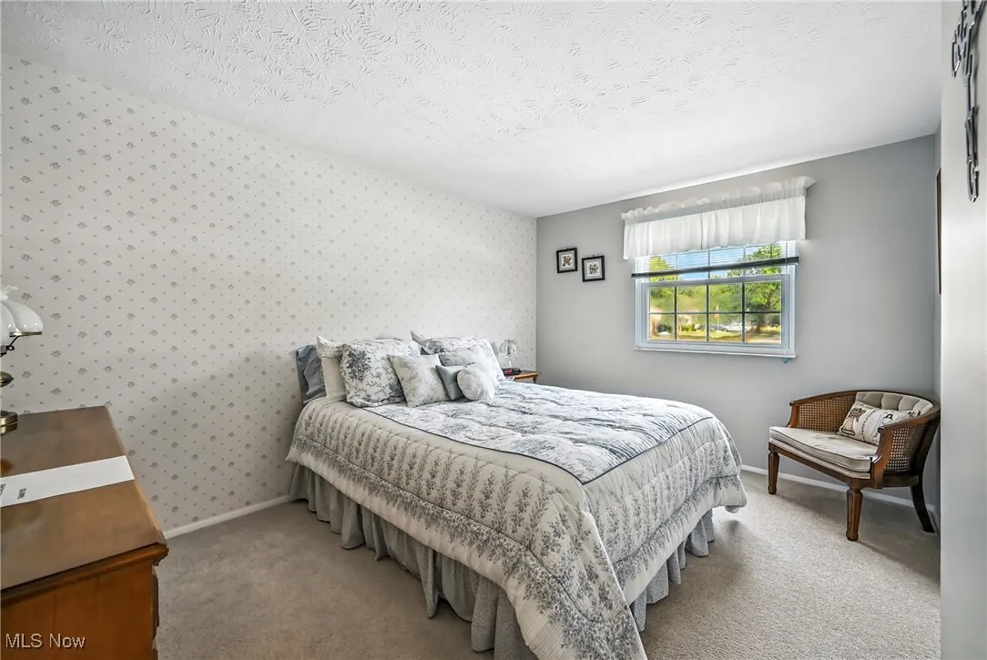 Carpeted bedroom with a textured ceiling and baseboards