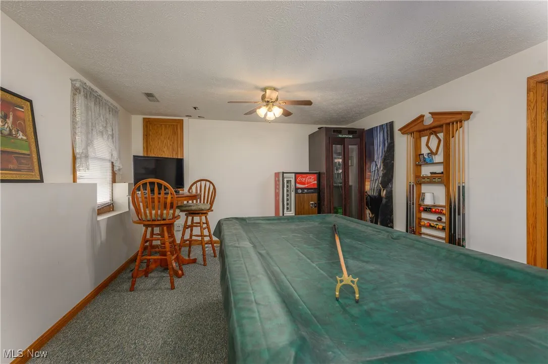 Recreation room featuring billiards, a textured ceiling, carpet flooring, and ceiling fan