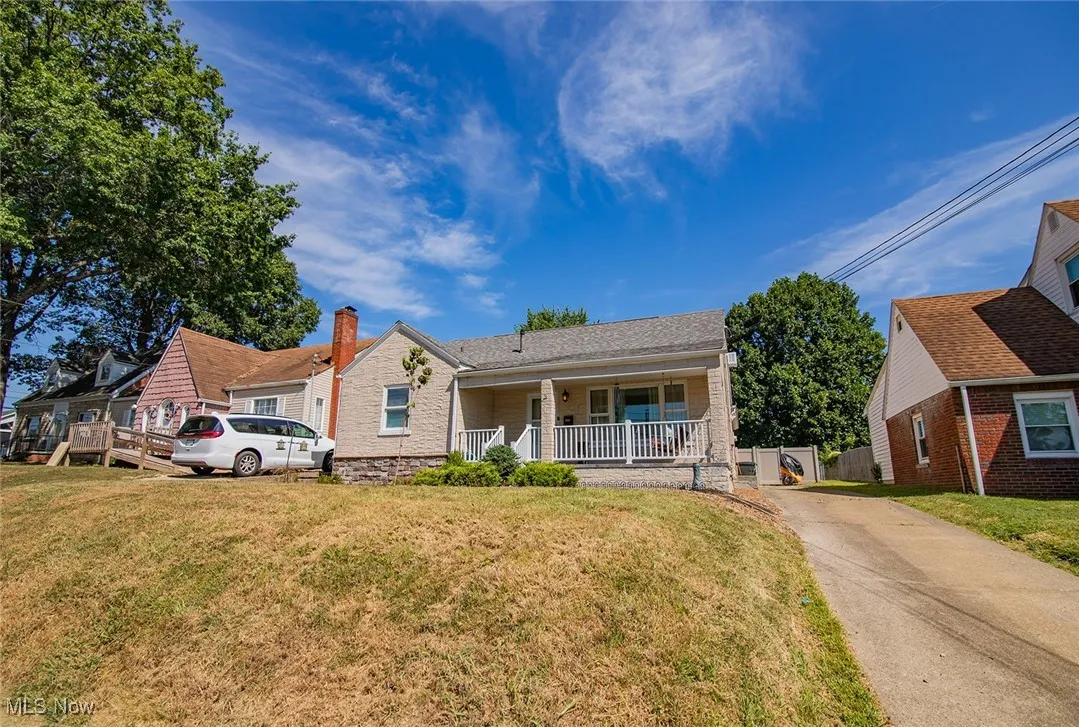 View of front of property featuring covered porch, a front lawn, concrete driveway, and roof with shingles