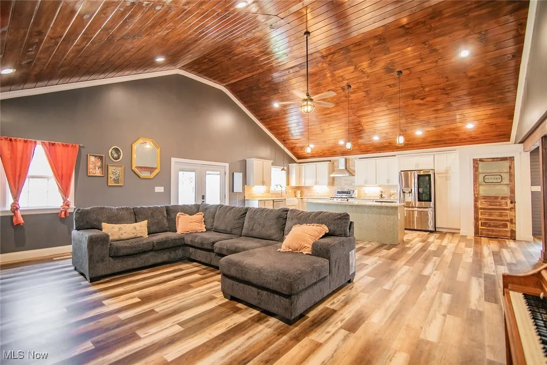 Living room featuring recessed lighting, wood ceiling, high vaulted ceiling, light wood-style floors, and ornamental molding