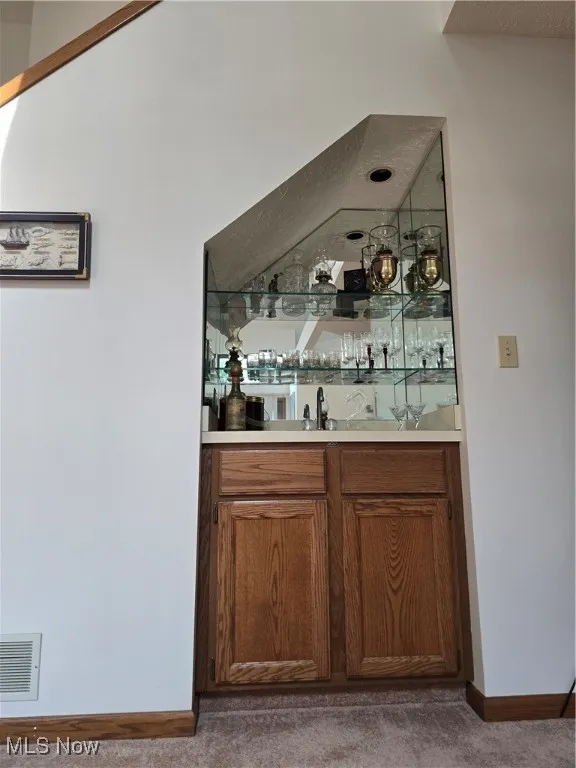 Indoor wet bar with brown cabinets and light countertops