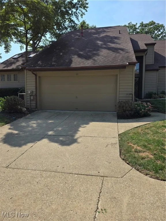 View of front of condominium with garage attached garage, and concrete driveway