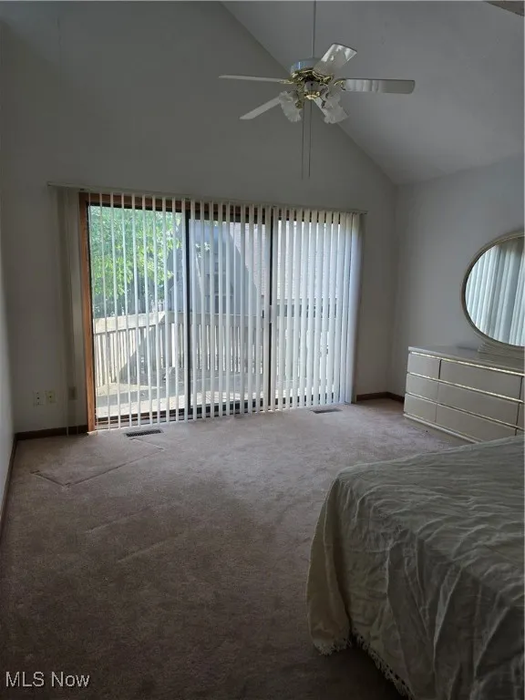 Carpeted Master Bedroom with high vaulted ceiling, access to exterior deck, and ceiling fan