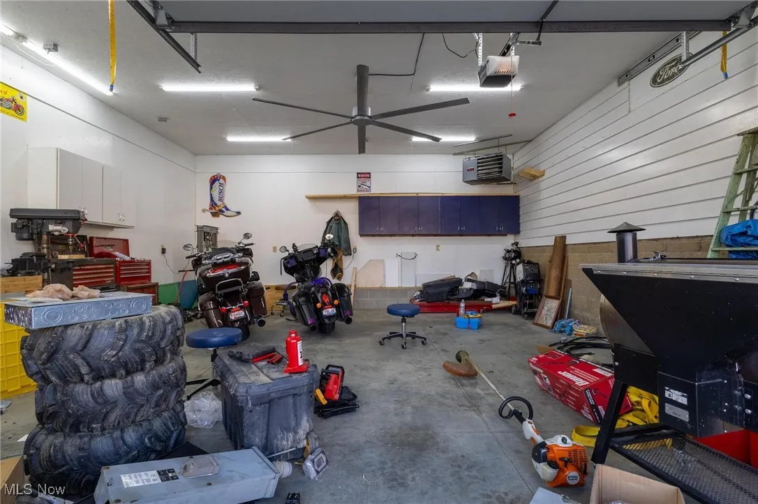 Garage featuring a heating unit, a garage door opener, and a workshop area