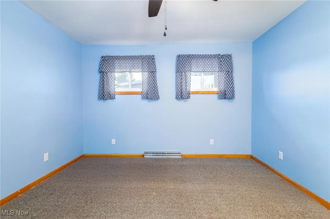 Spare room with carpet floors and a ceiling fan