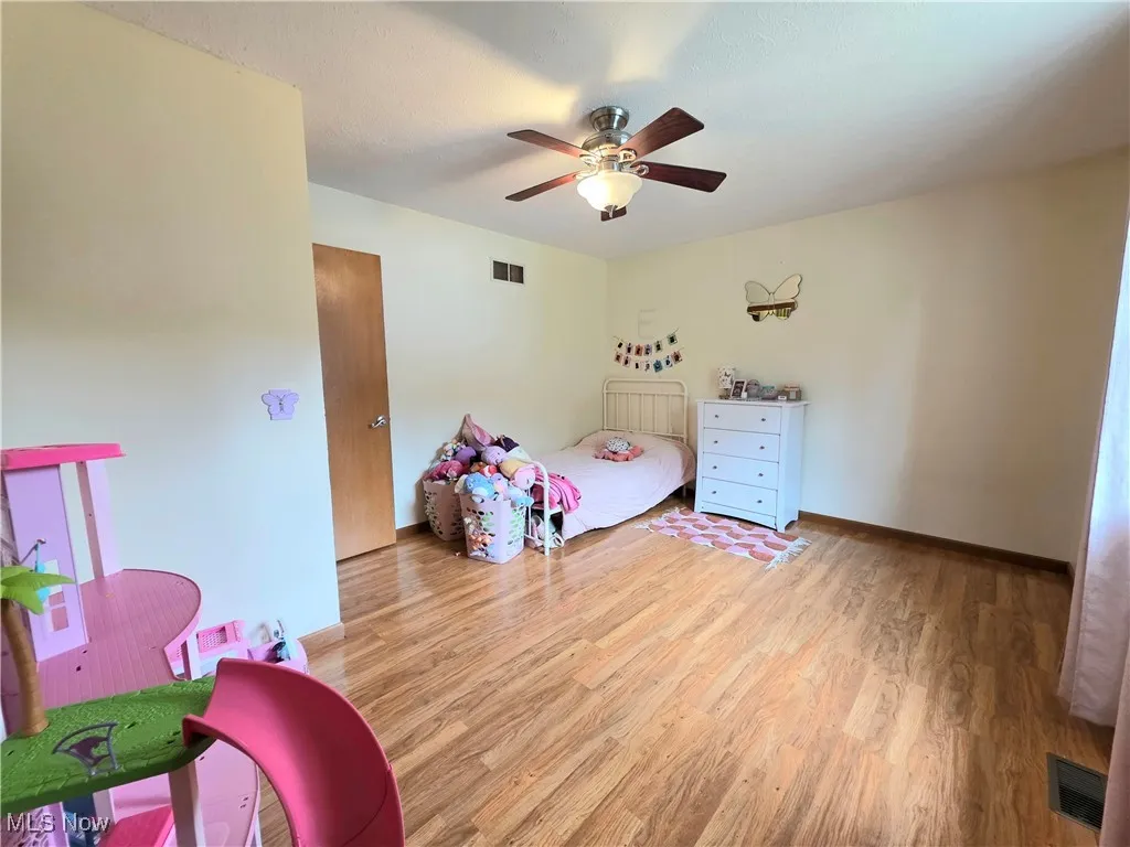 Bedroom with wood finished floors and ceiling fan