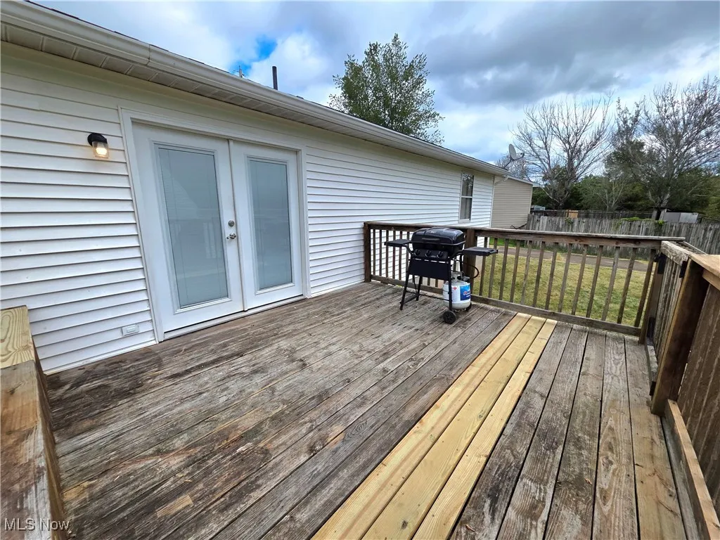 Wooden deck featuring a grill