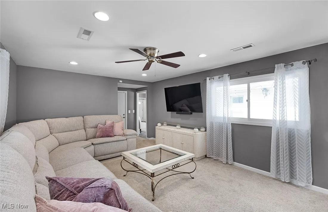 Carpeted living room with recessed lighting and a ceiling fan