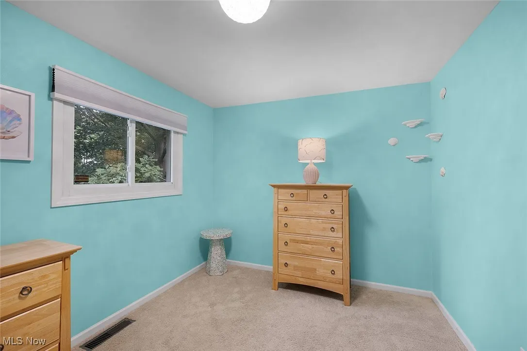 Bedroom featuring light carpet and baseboards