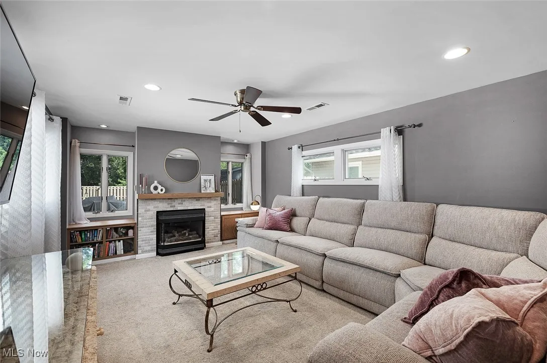 Living area with recessed lighting, healthy amount of natural light, carpet floors, a brick fireplace, and ceiling fan