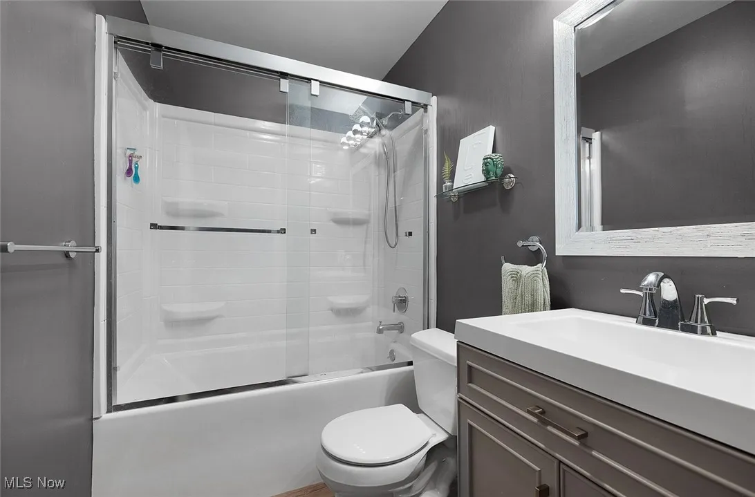 Full bath with bath / shower combo with glass door and vanity