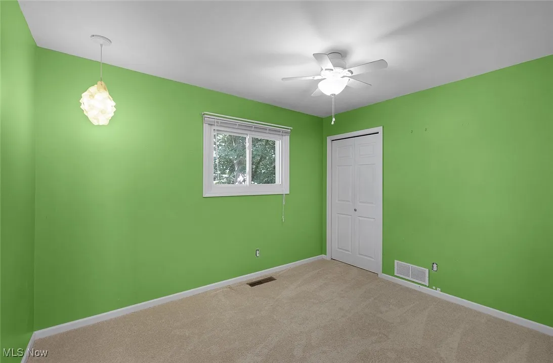 Unfurnished bedroom featuring carpet flooring, a closet, and a ceiling fan