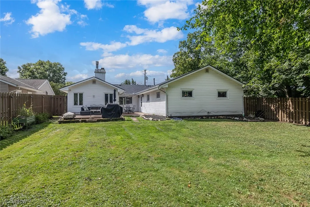 Rear view of property featuring a fenced backyard, a patio, and a chimney