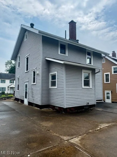 Rear view of house featuring a chimney