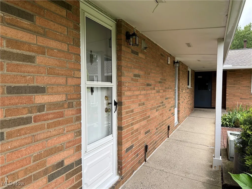 Side entry leads to patio. Laundry & trash room at end of sidewalk