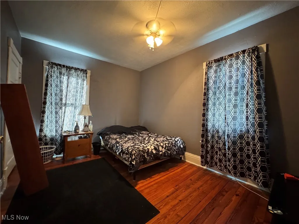 Bedroom featuring dark wood finished floors, a textured ceiling, and ceiling fan